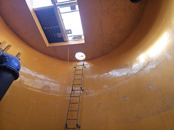 Interior of a large HDPE tank showing welded seams and access hatch