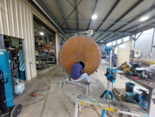 Fabricator working on a tank end inside the Beerwah workshop